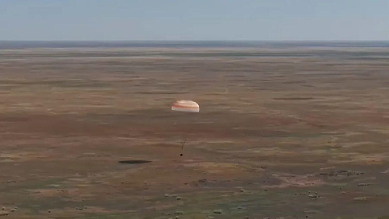 The Soyuz MS-28 descent module suspended under its main parachute during the final seconds of descent over the Kazakh steppe on July 26, 2026.