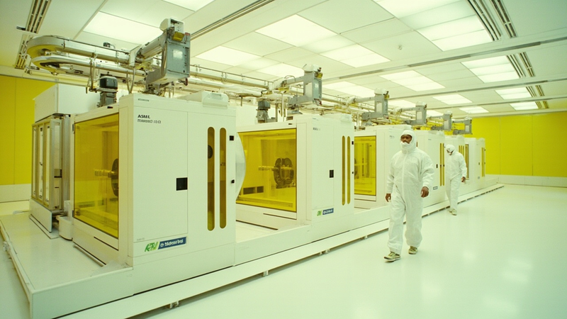 A row of EUV lithography scanners inside a modern semiconductor cleanroom, similar to the equipment installed at Rapidus's IIM-1 pilot fab in Chitose, Hokkaido.