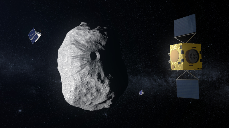 A gold-foiled spacecraft with solar wings holds station beside a large grey asteroid marked by a central crater, with two small cubesats nearby.