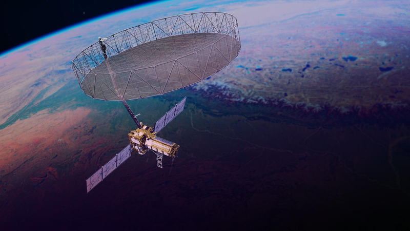 A radar satellite carrying a large drum-shaped mesh reflector on a boom flies above a false-colour landscape of river valleys and lakes.