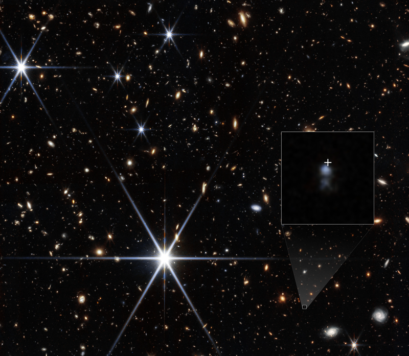A composite NIRCam image centred on the host galaxy of FRB 20240304B in the constellation Virgo at right ascension 12:11:59 and declination +11:48:46, showing a faint blue dwarf galaxy inside a small inset box with a white cross marking the exact radio position of the burst, set against a crowded field of more distant galaxies and brighter foreground stars with diffraction spikes. Image: NASA Webb release assets at science.nasa.gov/asset/webb/frb-20240304b-nircam-image, credit NASA, ESA, CSA, STScI, Themiya Nanayakkara (USYD); image processing Joseph DePasquale (STScI).